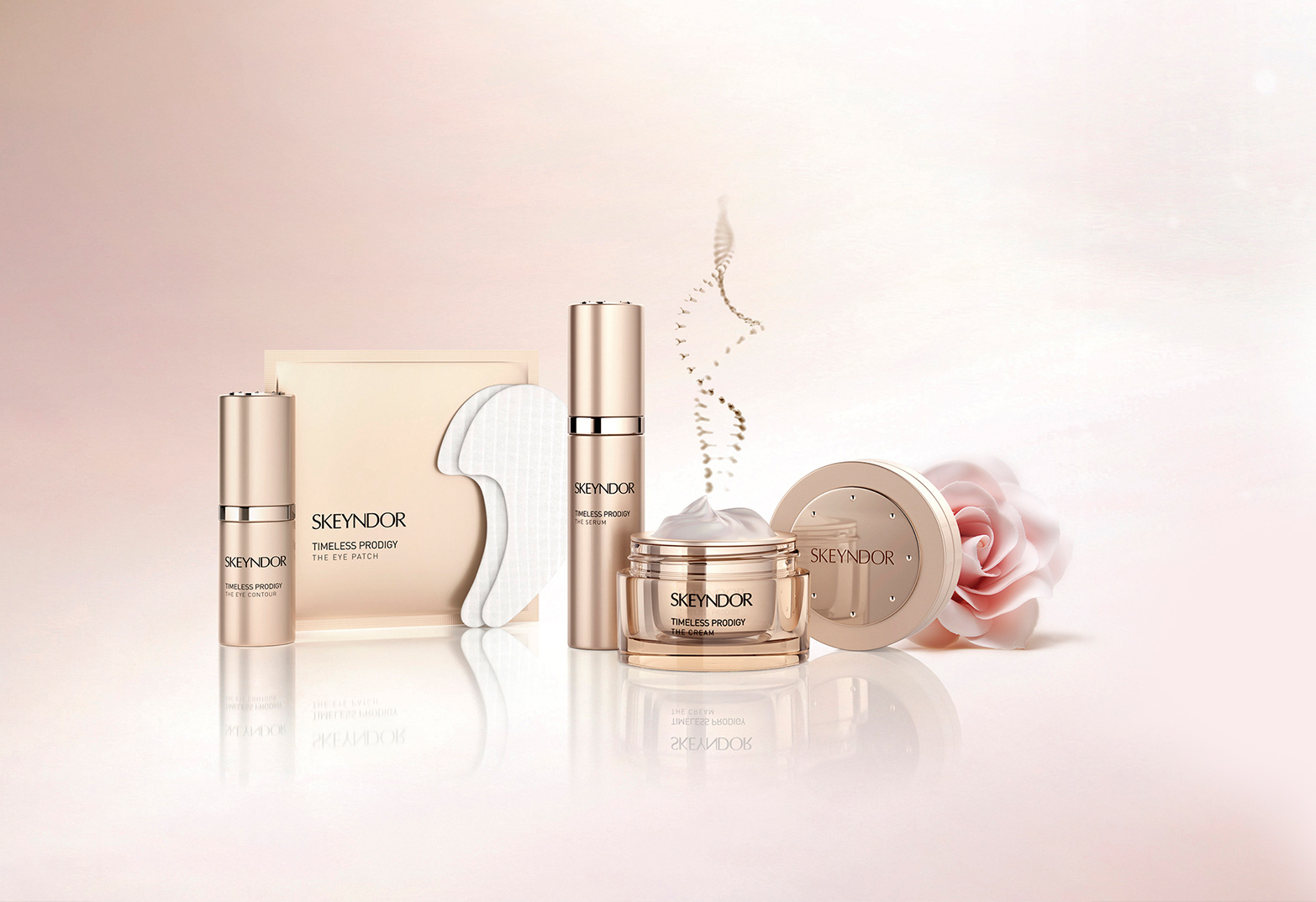 Mehrere Skeyndor Timeless Prodigy Hautpflegeprodukte in goldfarbenen Behältern vor hellem Hintergrund mit einer rosafarbenen Blüte